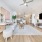 Spacious and well lit living room with wood flooring, large windows and open access to the kitchen