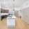 Spacious and well lit kitchen with wood flooring and stainless steel appliances