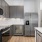 Spacious and well lit kitchen with wood flooring and stainless steel appliances