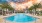 Large sparkling blue pool with a large pool deck and lounge chairs