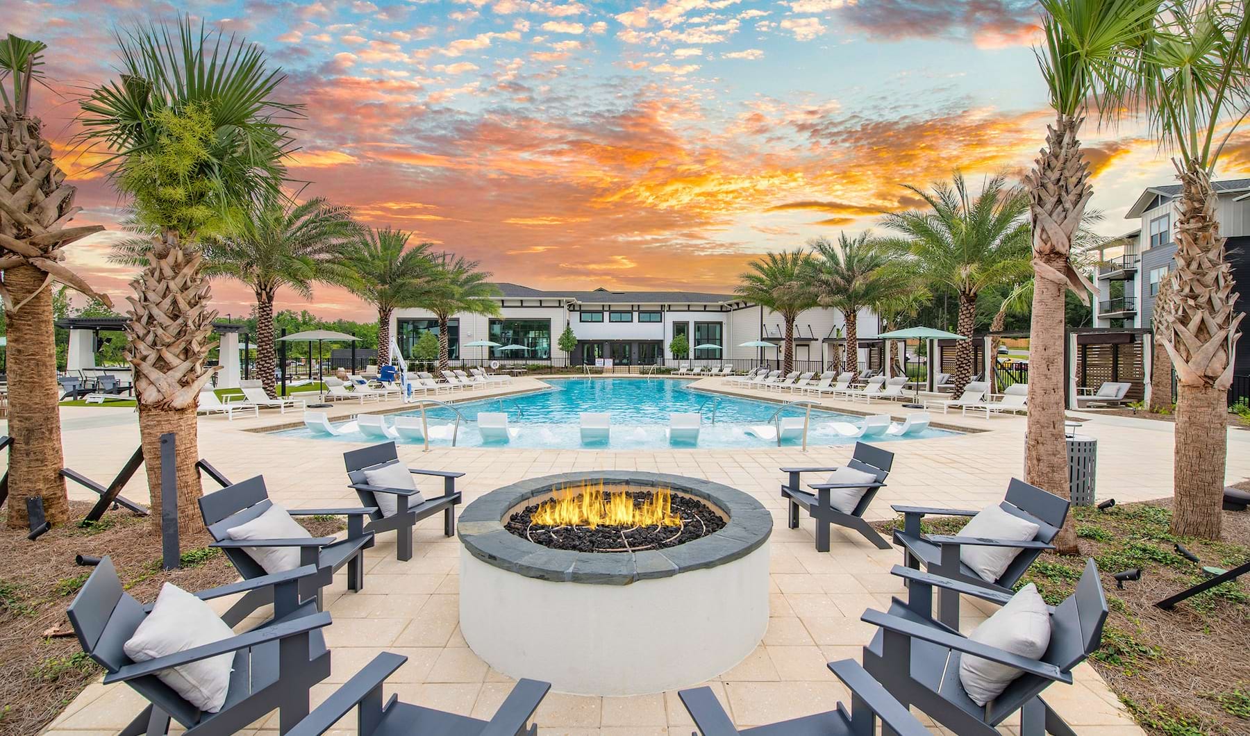 Large sparkling blue pool with a large deck and lounge chairs 